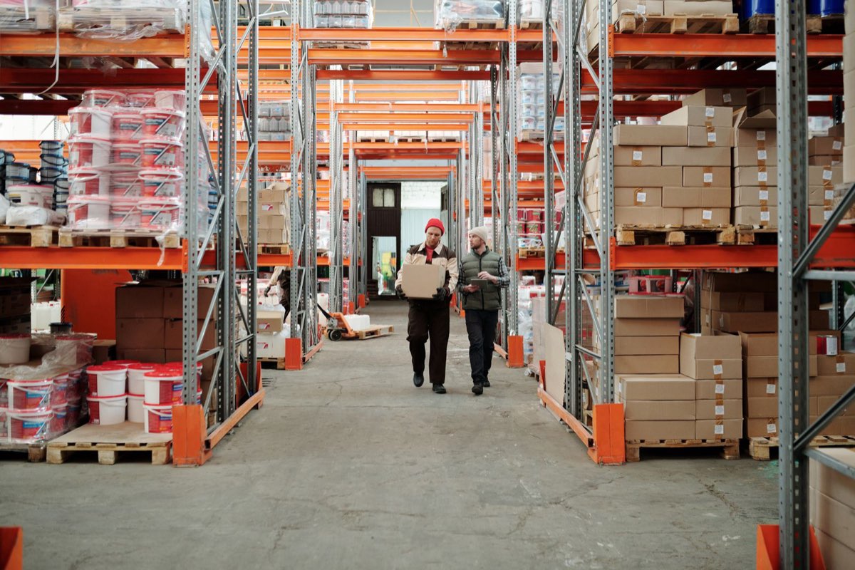 Amazon warehouse associate scanning a package on the fulfillment center floor