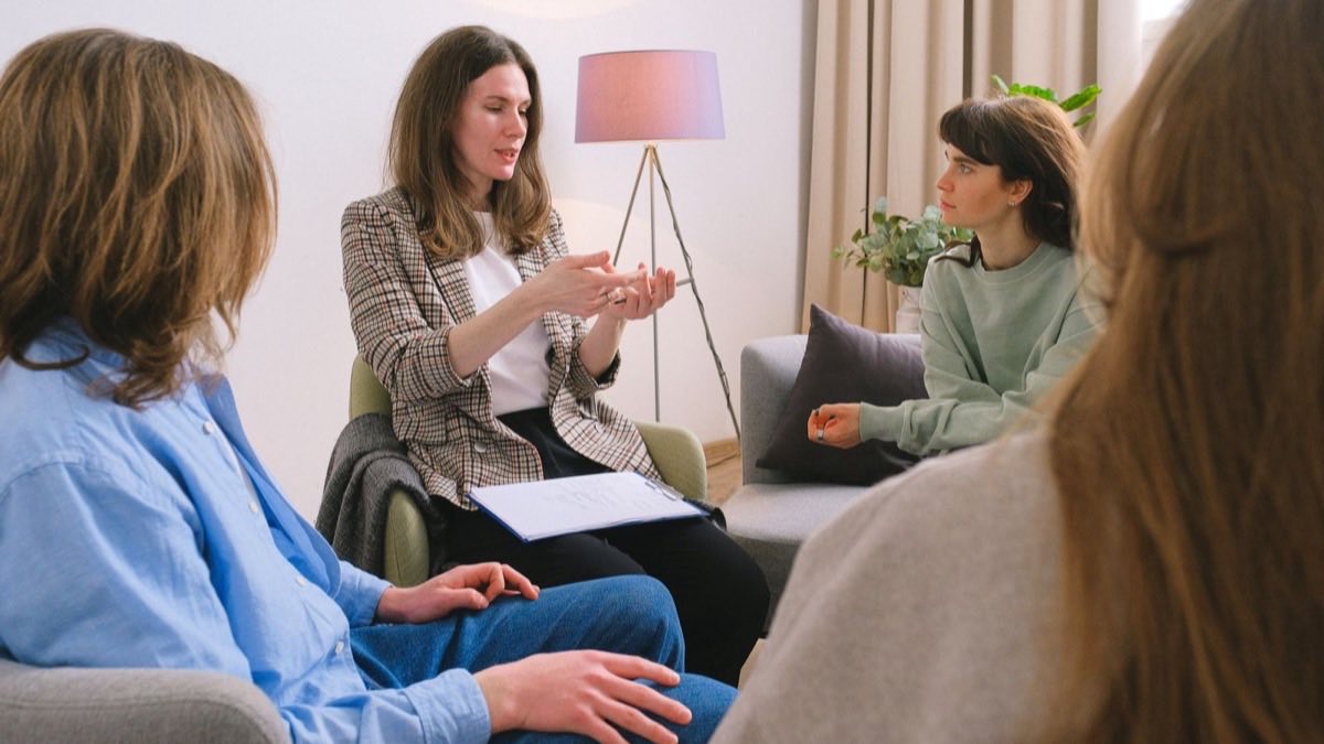 A caring professional listening closely while supporting someone through a one on one conversation