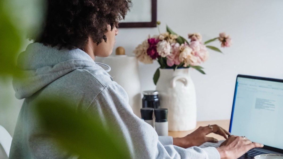 A person working independently at a quiet home desk, focused and undisturbed by a team
