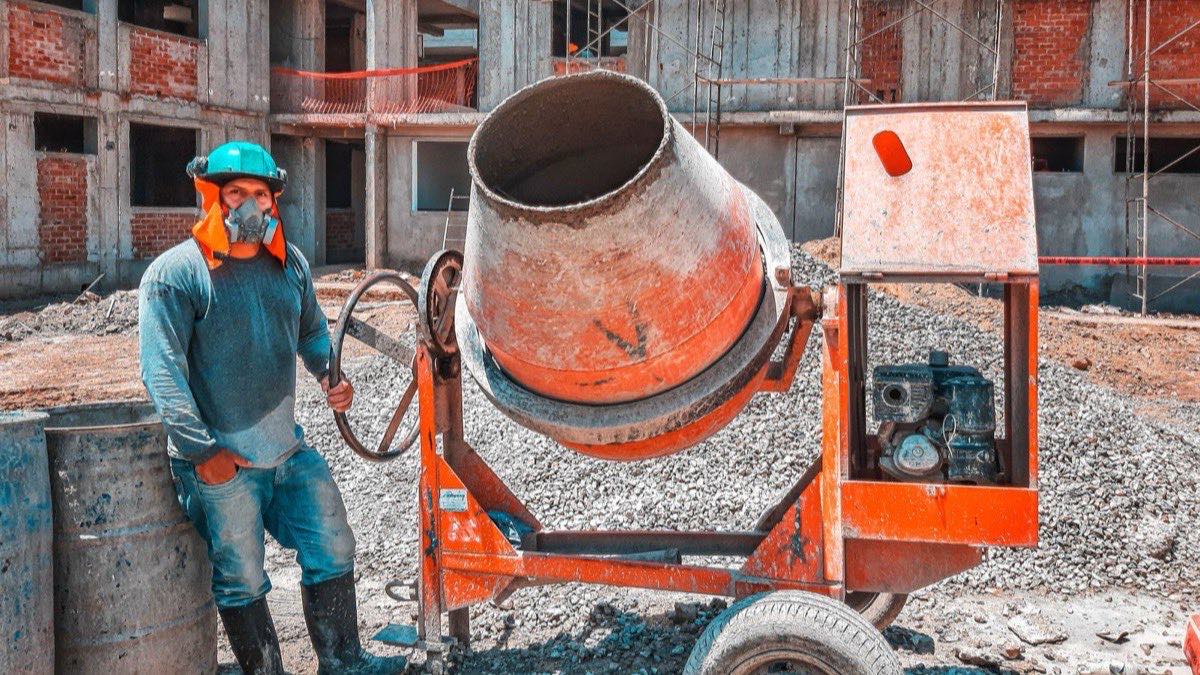 Construction laborer handling materials and using hand tools on an active job site