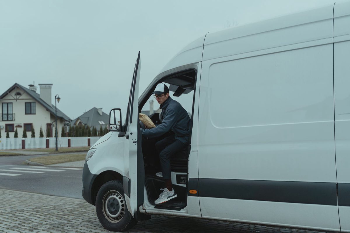 Delivery driver carrying parcels from a van
