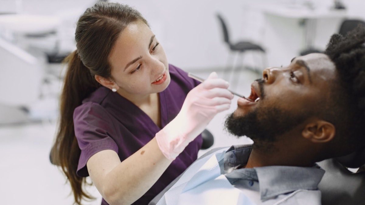 Dental assistant preparing instruments chairside during a patient exam
