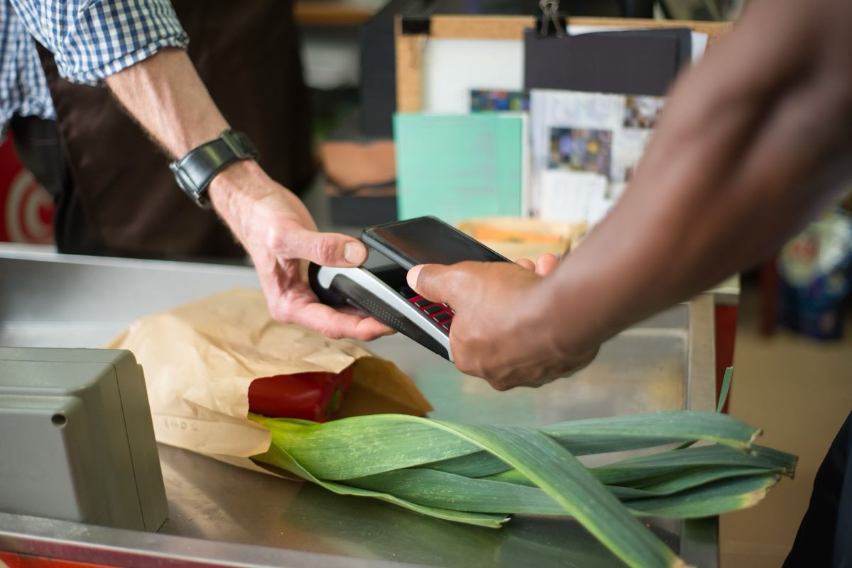 Cashier completing a customer's card payment at a grocery checkout lane