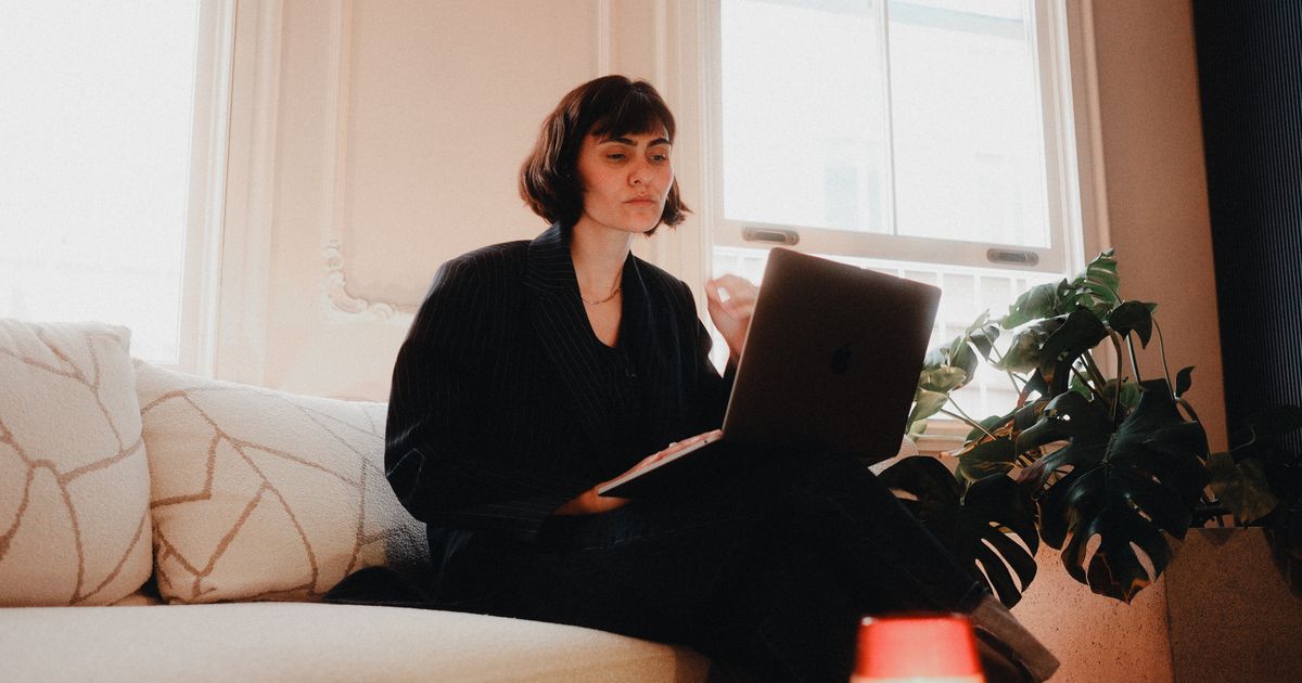 A relaxed professional working calmly on a laptop by a window