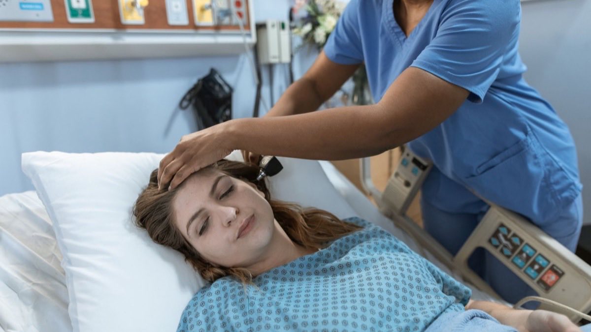 Medical assistant taking a patient's blood pressure in a clinic exam room