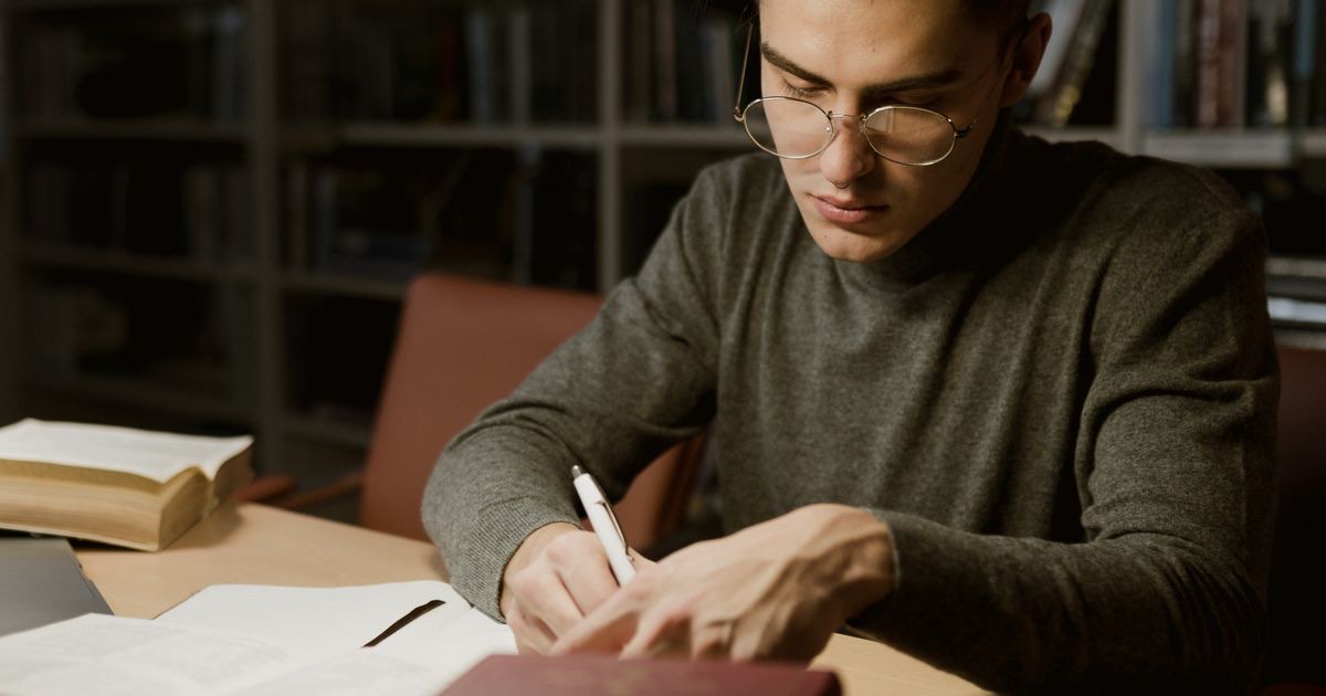 Job seeker rewriting resume bullet points on a laptop