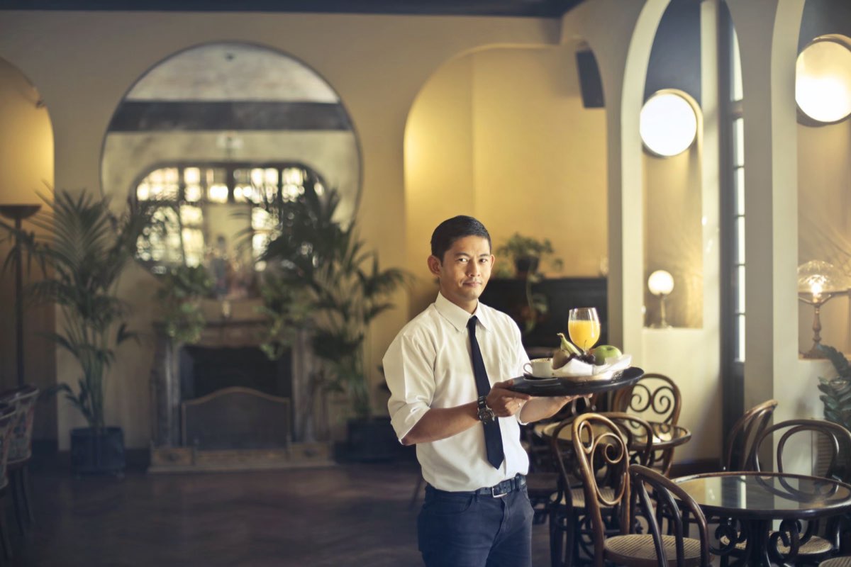 Restaurant server delivering plates to a table