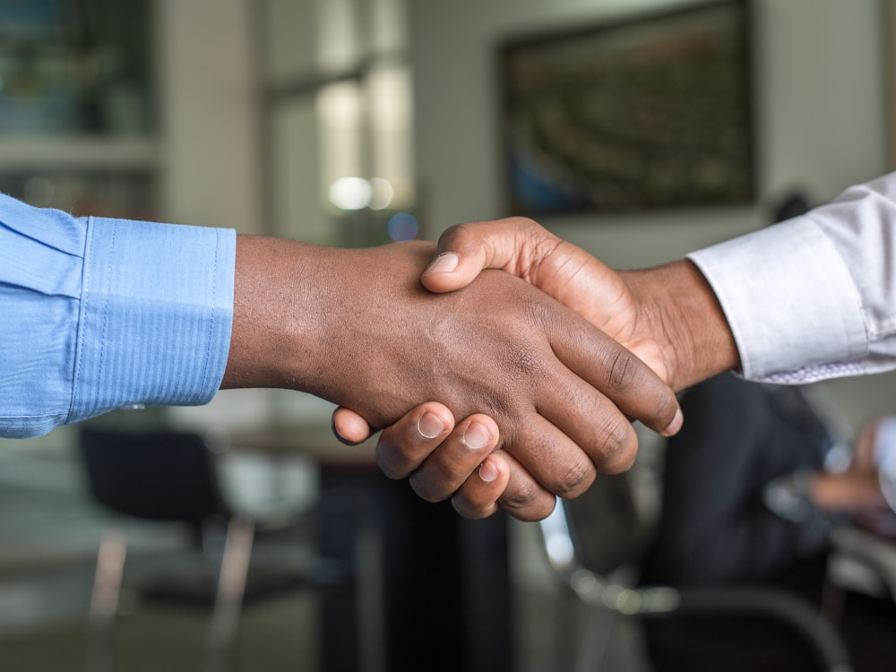 A ResumeCroc client and writer shaking hands on a successful resume